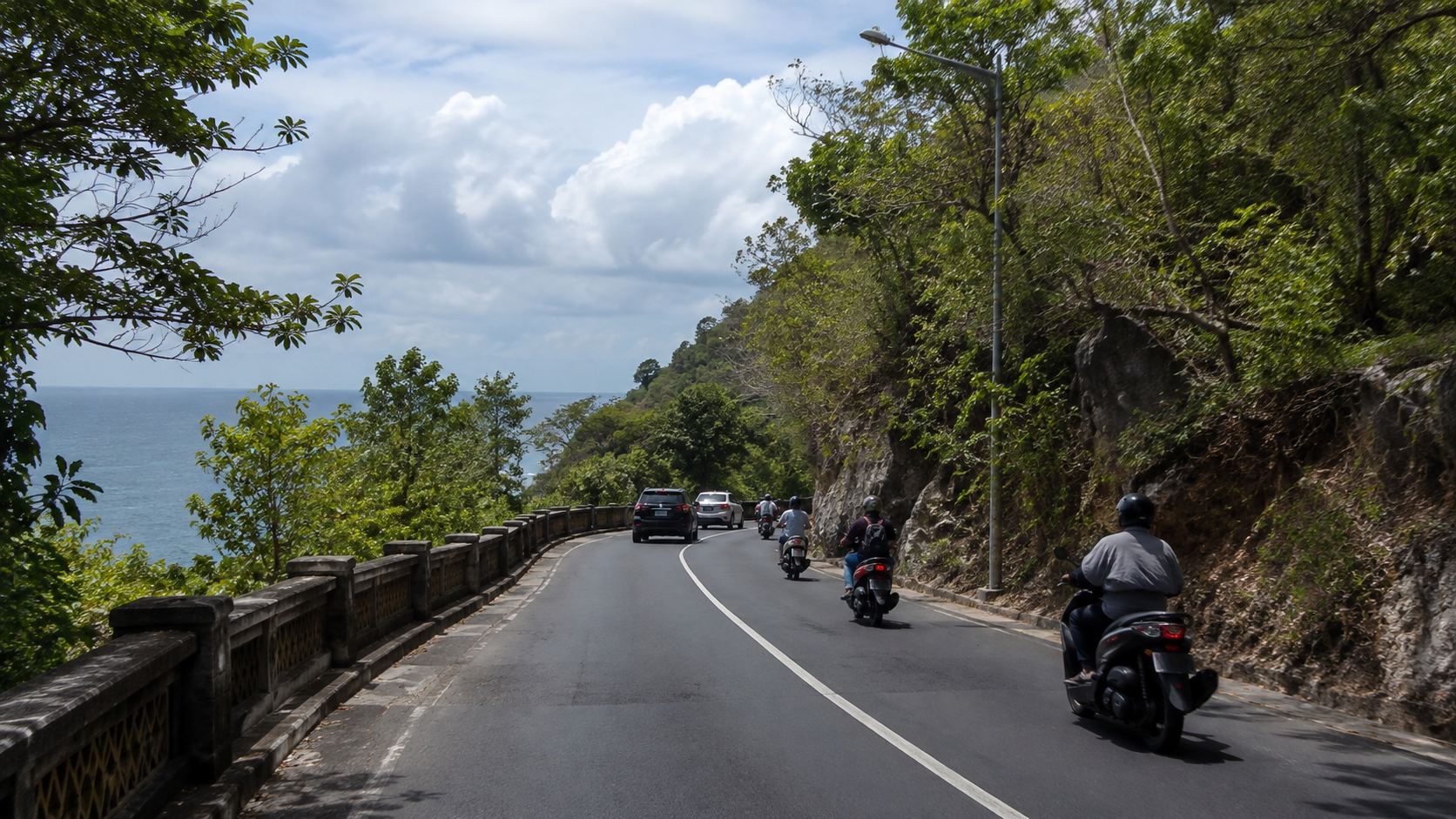 South Bali Coastal Route Cars and scooters traveling along a coastal road in South Bali
